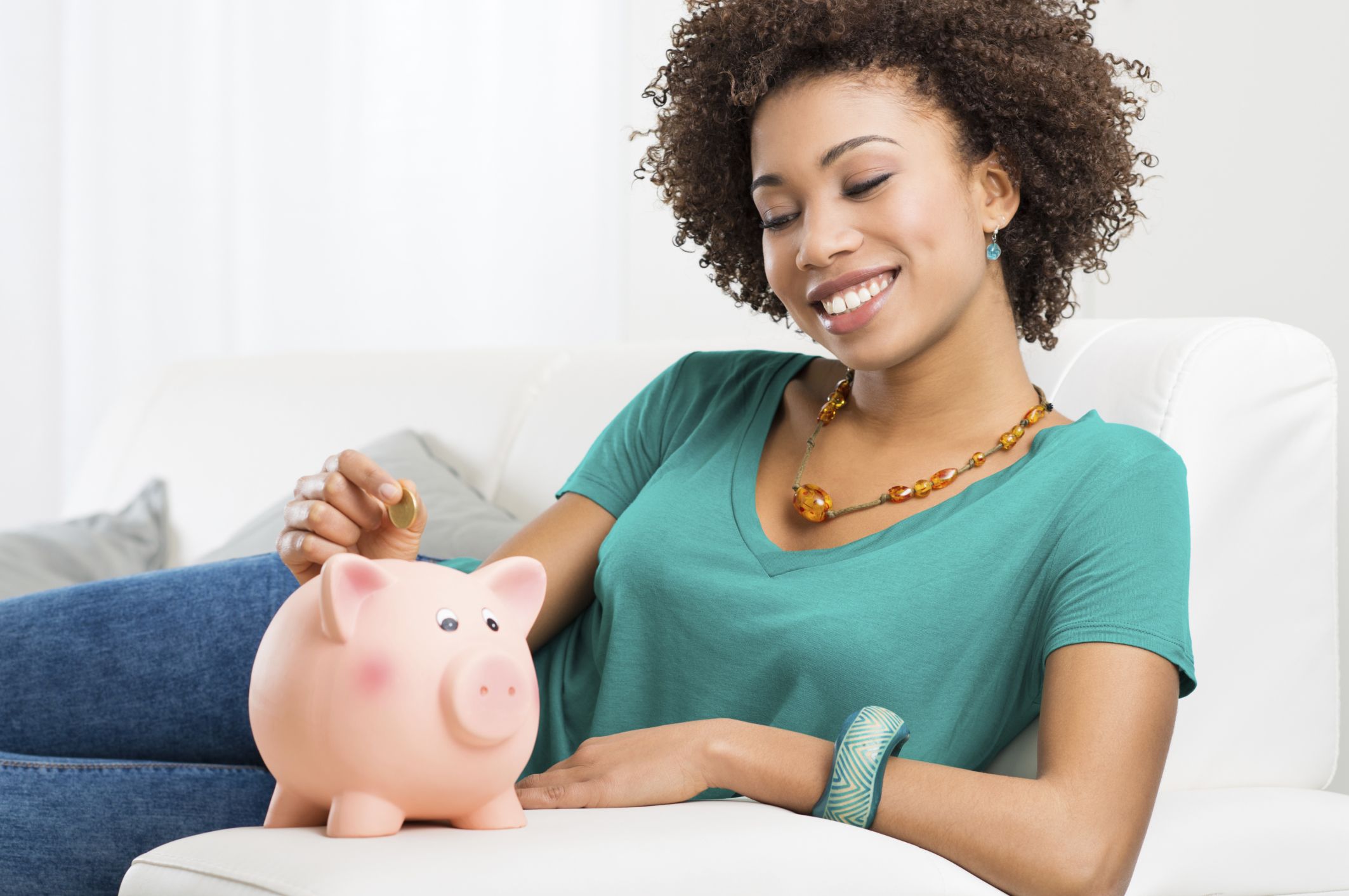 Woman Putting Coin In Piggybank