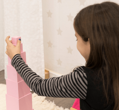 Niña construyendo la Torre Rosa, el material Montessori más icónico y representativo del método montessori