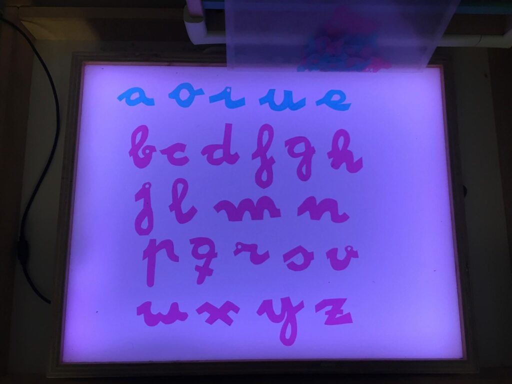 Letras del alfabeto móvil Montessori sobre una mesa de luz. Alfabeto Montessori DIY