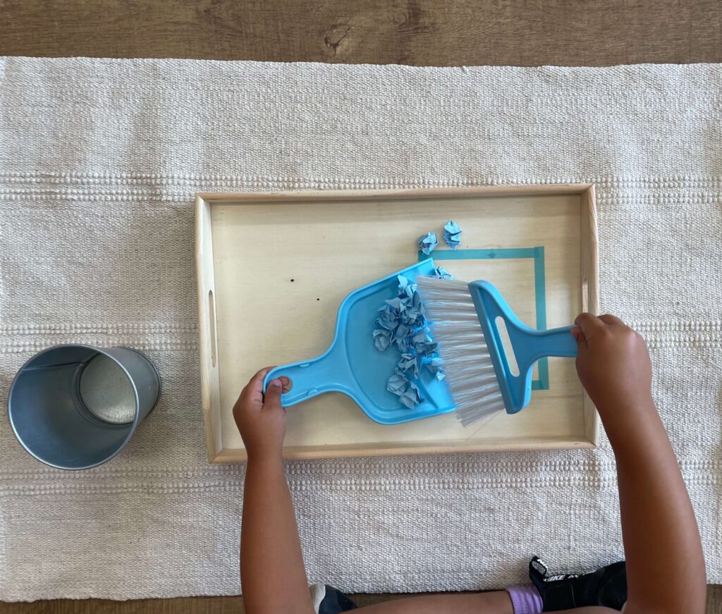 Bandeja Montessori para la actividad de barrer, del área de vida práctica